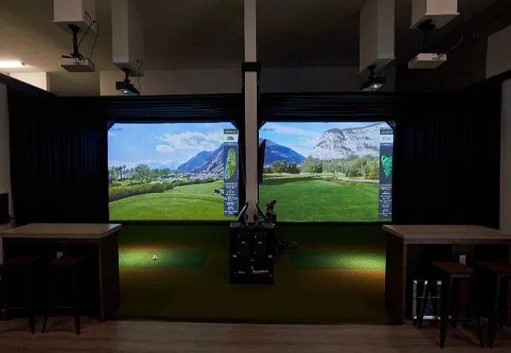 Two Full Circle Golf simulator bays with high-top tables